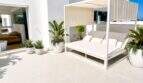 Sonnige Dachterrasse der Designvilla in Portixol mit weißem Cabana-Daybed, Palmen und Meerblick