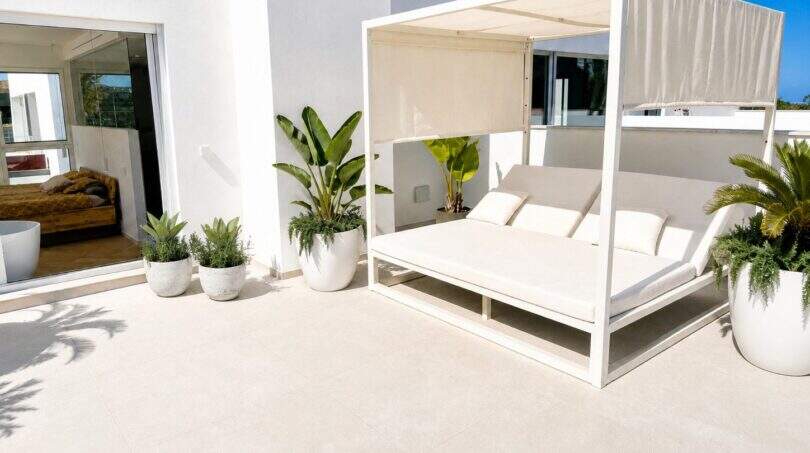 Sonnige Dachterrasse der Designvilla in Portixol mit weißem Cabana-Daybed, Palmen und Meerblick