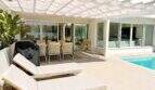 Sonnige Poolterrasse der Designvilla in Portixol mit Loungebetten, Pergola und elegantem Außenbereich.