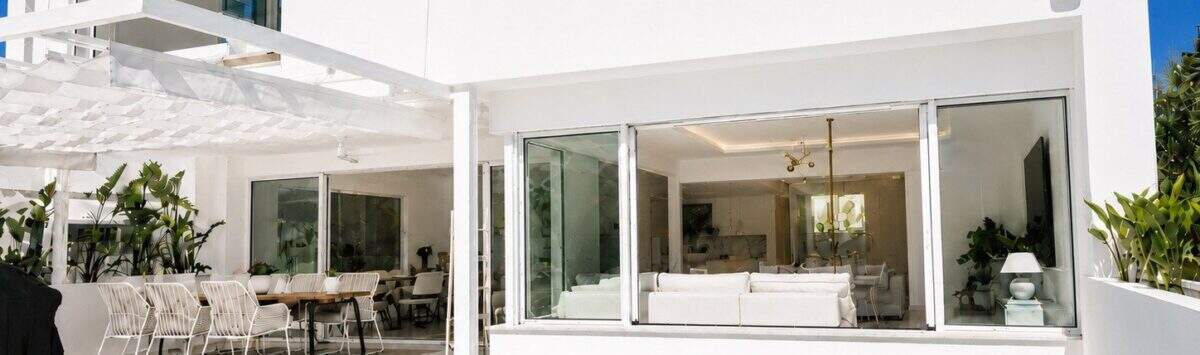 Außenansicht der Designvilla in Portixol mit türkisem Pool, weißer Fassade und offenem Wohnbereich
