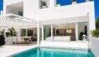 Außenansicht der Designvilla in Portixol mit türkisem Pool, weißer Fassade und offenem Wohnbereich