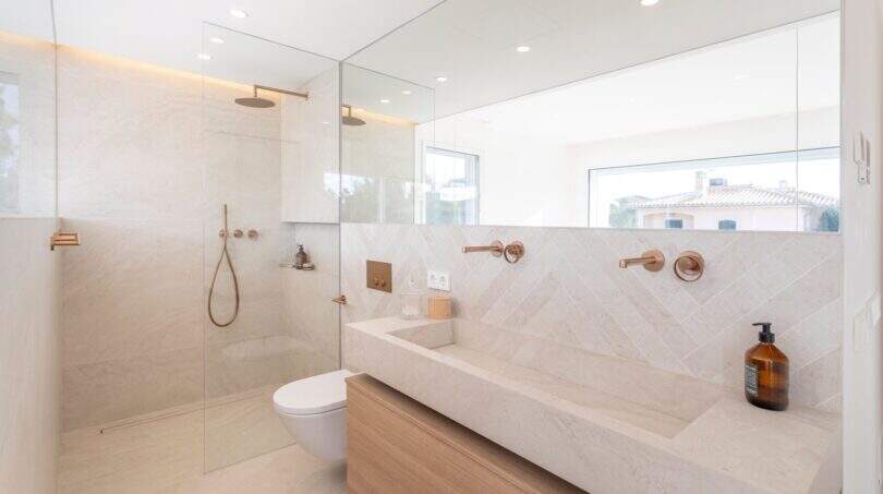 Modernes Badezimmer der Designvilla in Portixol mit Marmor, Regendusche und Roségold-Armaturen.