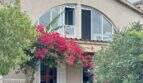 Außenansicht der Mallorca-Finca in Marratxí mit Bougainvillea, großem Rundbogenfenster und mediterranem Garten.