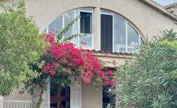 Außenansicht der Mallorca-Finca in Marratxí mit Bougainvillea, großem Rundbogenfenster und mediterranem Garten.