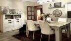 Helles Esszimmer der Mallorca-Finca mit Holztisch, weißen Stühlen, Sideboard und elegantem Kronleuchter.