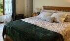 Helles Schlafzimmer der Mallorca-Finca mit Doppelbett, Holzboden, Klimaanlage und Gartenblick