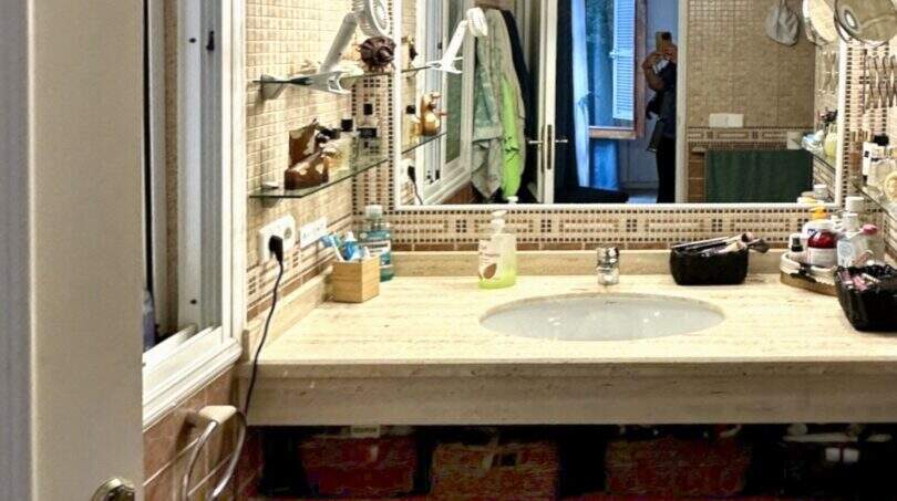 Badezimmer der Mallorca-Finca mit Mosaik-Fliesen, Marmorwaschtisch und großem Spiegel mit Beleuchtung.