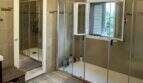 Geräumiges Badezimmer der Mallorca-Finca mit zwei Duschabteilen, Fenster und Holzoptikboden in Marratxí