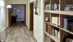 Heller Flur der Mallorca-Finca mit großem Bücherregal, Holzboden und Durchblick zu weiteren Zimmern