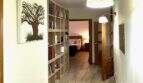 Heller Flur der Finca Marratxí mit Bücherregal, Wandlampen, Holzboden und Blick ins Schlafzimmer