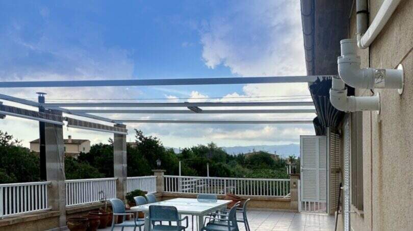 Überdachte Dachterrasse der Mallorca-Finca in Marratxí mit Glaspergola, Gartenmöbeln und Panoramablick.