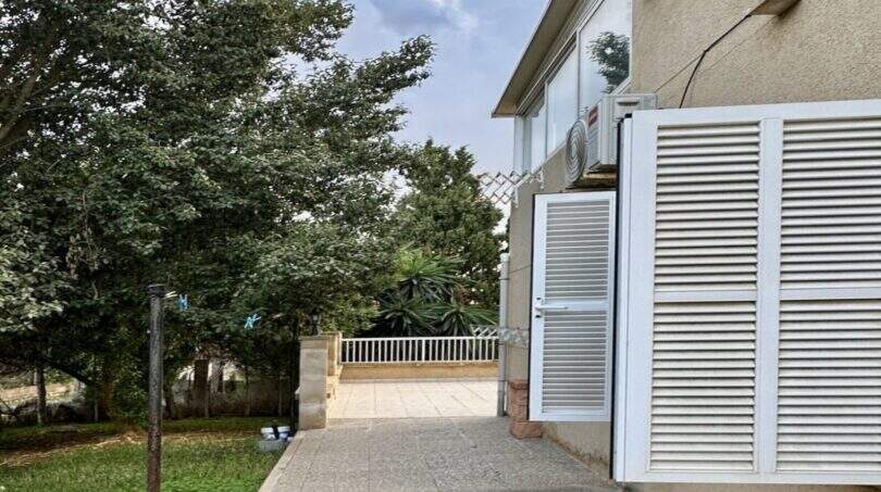 Seitlicher Gartenweg der Finca in Marratxí mit gepflasterter Terrasse, Rasenfläche und üppigen Bäumen