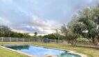 Großer Pool mit Steinrand, grüner Rasenfläche und Olivenbäumen auf Mallorca-Finca in Marratxí