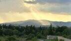 Panoramablick von Mallorca-Finca in Marratxí: Sonnenstrahlen über Bergen, mediterrane Vegetation und Zypressen.