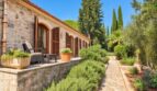 Mediterrane Natursteinfinca mit Holzläden, Terrasse und gepflegtem Garten mit Lavendel und Zypressen.