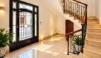Repräsentativer Eingangsbereich mit eleganter Treppe und hochwertigen Schmiedeeisen-Geländern