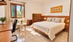 Schlafzimmer mit integriertem Arbeitsbereich und hochwertiger Holzausstattung