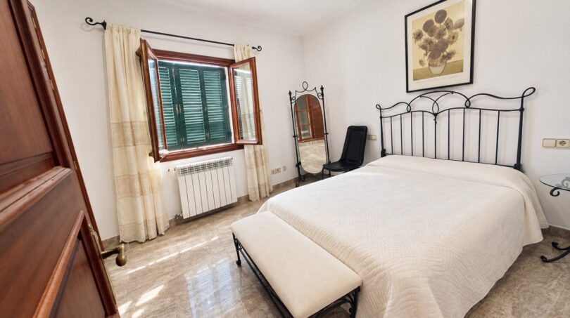 Helles Schlafzimmer mit Fensterfront und komfortabler Raumaufteilung