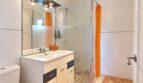 Modernes Badezimmer mit ebenerdiger Dusche und praktischem Waschtischunterschrank
