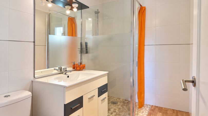 Modernes Badezimmer mit ebenerdiger Dusche und praktischem Waschtischunterschrank