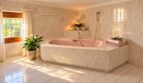 Luxuriöses Badezimmer mit freistehender Wanne und marmorierten Wandflächen - Wellness-Oase mit Tageslicht