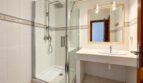 Modernes Badezimmer der Strandwohnung Playa de Palma mit Glasdusche, Waschtisch und Spiegel.
