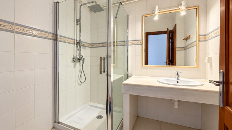 Modernes Badezimmer der Strandwohnung Playa de Palma mit Glasdusche, Waschtisch und Spiegel.