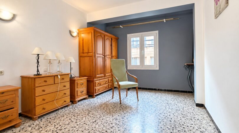 Schlafzimmer mit Holzmöbeln, Kommode, Kleiderschrank und Terrazzoboden in Strandwohnung Palma de Mallorca