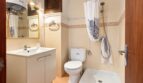 Helles Badezimmer mit Waschbecken, WC und Dusche in Strandwohnung Playa de Palma, Mallorca