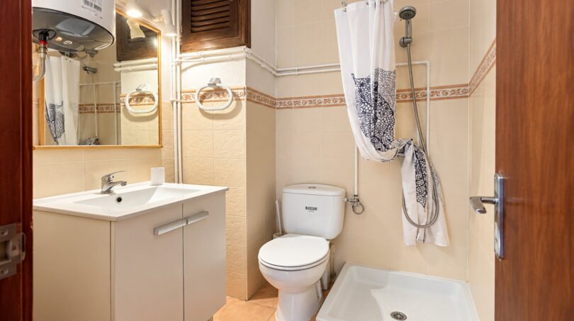 Helles Badezimmer mit Waschbecken, WC und Dusche in Strandwohnung Playa de Palma, Mallorca