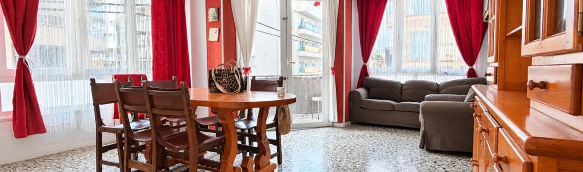 Wohnzimmer mit Essbereich, Holzmöbeln, roten Vorhängen und Terrakottaboden in Strandnähe, Palma de Mallorca