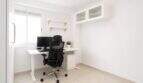 Helles Arbeitszimmer mit weißem Schreibtisch, ergonomischem Stuhl, Monitor und Wandschränken in Palma-Stadtwohnung
