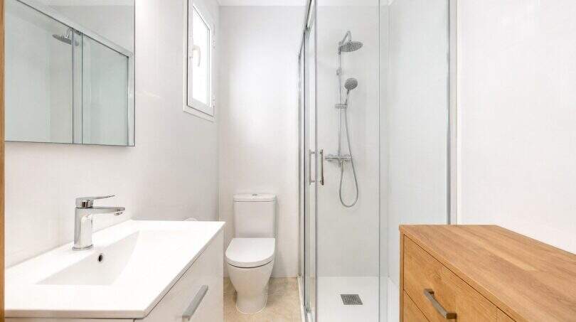 Modernes Badezimmer mit Glasdusche, WC und Holzkommode in Stadtwohnung mit Meerblick in Palma de Mallorca