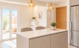Helle Küche mit Kochinsel, Pendelleuchten und Terrassenzugang im modernen Penthouse Palma de Mallorca