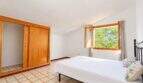 Hauptschlafzimmer mit begehbarem Kleiderschrank und großem Fenster zur Naturaussicht
