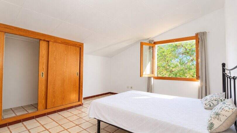 Hauptschlafzimmer mit begehbarem Kleiderschrank und großem Fenster zur Naturaussicht