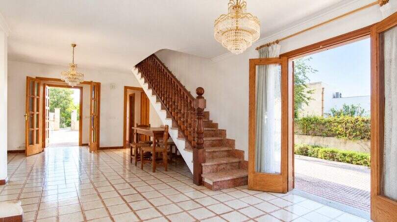 Repräsentativer Eingangsbereich mit eleganter Treppe und direktem Zugang zum Außenbereich