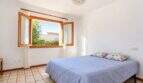 Helles Schlafzimmer mit Panoramafenster und Ausblick ins Grüne