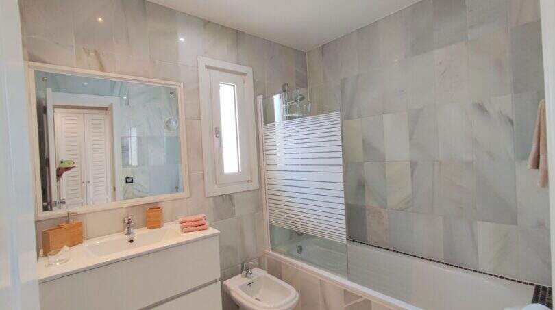Modernes Badezimmer mit Badewanne, Bidet und Marmorfliesen in der Ferienvilla über der Bucht von Cala Mandia