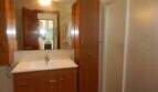Modernes Badezimmer mit Holzunterschrank, Waschbecken, Duschkabine und Hochschrank im Chalet Portocolom