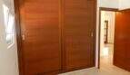Schlafzimmer mit großem Einbauschrank aus Holz mit Schiebetüren im modernen Chalet in Portocolom