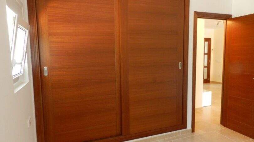 Schlafzimmer mit großem Einbauschrank aus Holz mit Schiebetüren im modernen Chalet in Portocolom